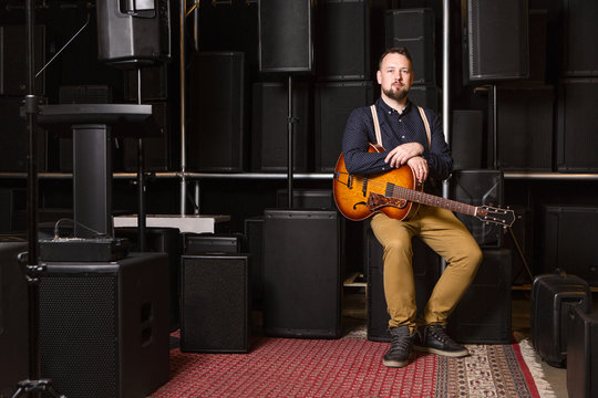 Guitarist sitting on guitar combo