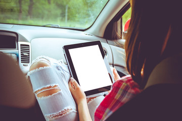 Girl with tablet in her hands in the car. Hitchhiking, car ride concept