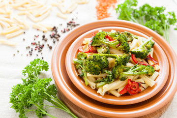 Delicious pasta with roasted vegetables on a plate closeup