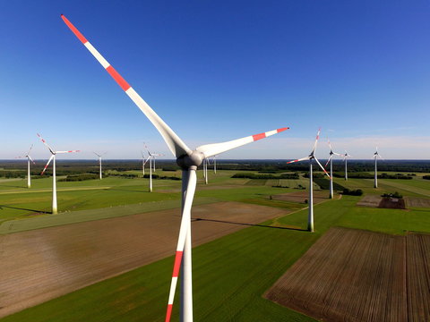 Windenergieanlagen auf Feld vor Wald