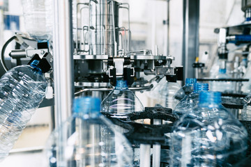 Bottling plant - Water bottling line for processing and bottling pure spring water into blue bottles. Selective focus. 