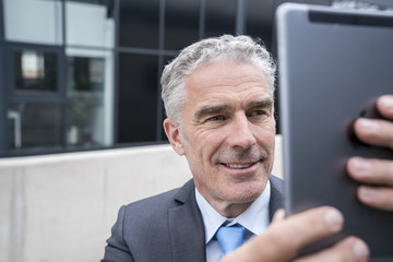 Obraz na płótnie Canvas Mature businessman taking a smartphone selfie