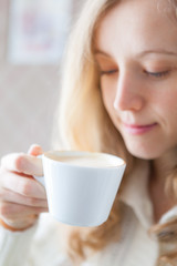 Coffee. Beautiful young woman holding in hand a cup of coffee