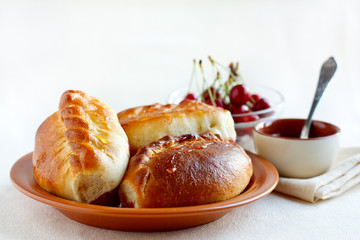 Sweet patties with cherry  on a rustic plate