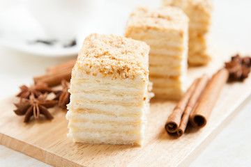 Cake Napoleon of puff pastry with sour cream on a plate close-up