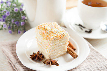 Cake Napoleon close-up, cinnamon and anise with a cup of tea