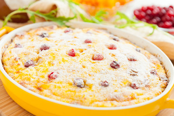 Curd pudding with cranberries and raisins close-up in dish