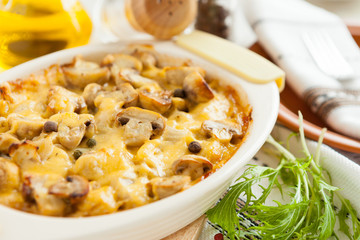 Baked mushrooms, potatoes and cheese on a pan closeup