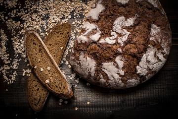 Traditional Whole Grain Rye Bread on Dark Wooden Table Background