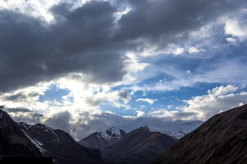 Горный пейзаж, красивый вид на живописное ущелье, высокие снежные склоны, облачное небо над горами, природа Кавказа, Грузия