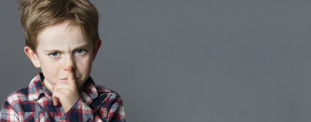 unhappy young boy sulking with finger on lips for secret © STUDIO GRAND WEB