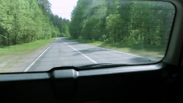 Driving a car on a forest road, view from the outside 4k