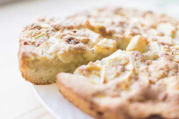 Apple pie and a cut piece on a plate