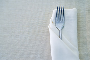 Close up fork on white napkin in restaurant