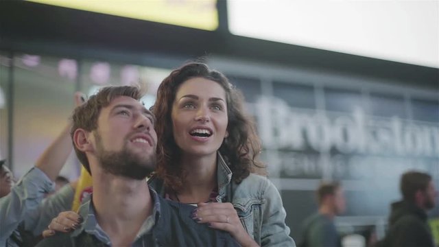 Couple looking at illuminated billboards in Times Square, New York City, New York