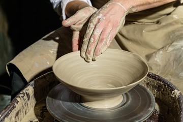 Hands working on pottery wheel
