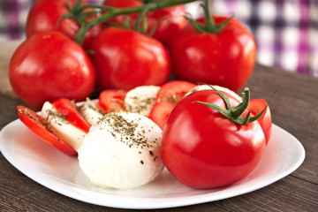 Fresh tomato with mozzarella cheese on a white plate