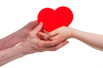 Old and young hands holding red heart, isolated on a white background.