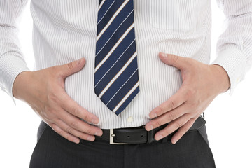 お腹に手をあてるスーツ姿の男性