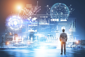 Young businessman looking at glowing graphs