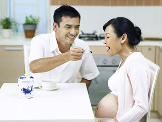 husband feeding pregnant wife