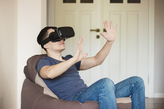 Man plays game with virtual reality glasses indoors