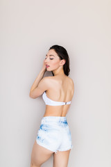 Fototapeta premium Beautiful woman wearing jeans shorts and bra isolated