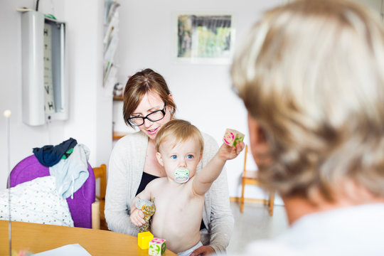 Baby (12-17 months) with mother and doctor in examination room