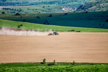 Obraz premium Tractor harrows the ground