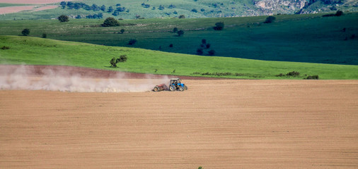 Tractor harrows the ground