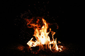 Bonfire with flames. Fire with flames background with bright vivid flame on black background. Shallow depth of field.