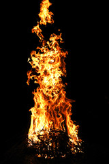 Big bonfire flame. Fire background with bright vivid flame on black background. Shallow depth of field.