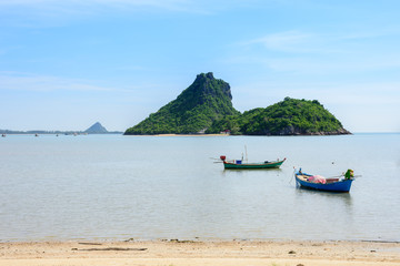 Fototapeta na wymiar Beachfront scenery with fishing boats landing at Prachuap Khiri Khan, Thailand.