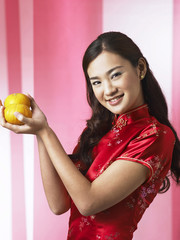 young woman holding mandarin oranges