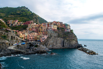 Fototapeta na wymiar Manarola Italy - colorful houses on a rock above the sea with a small harbor in the Cinque Terre region of Italy.