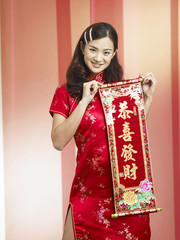 woman holding a red banner with text greeting happy chinese new year