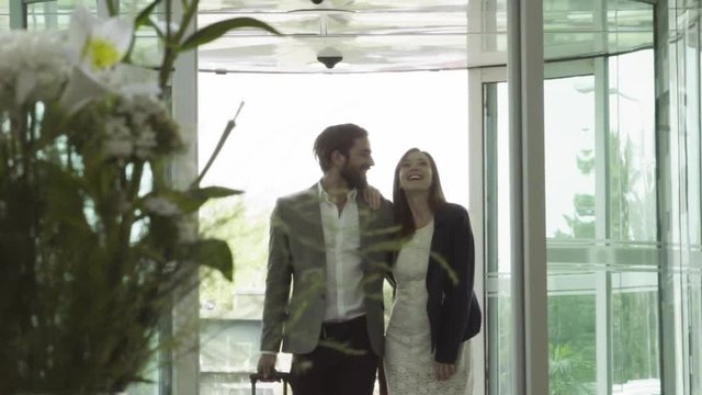 Happy couple entering luxury hotel