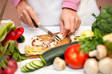 Housewife cutting champignons