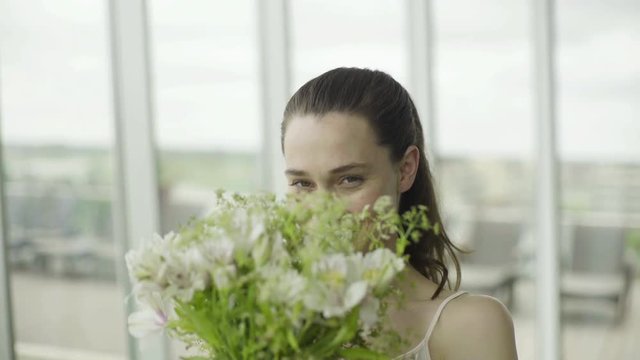 Young woman smelling bouquet of fresh flowers