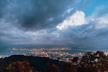 Dusk cloudy sky, cityscape and mountain with green that viewed from Penang Hill at George Town. Penang, Malaysia.