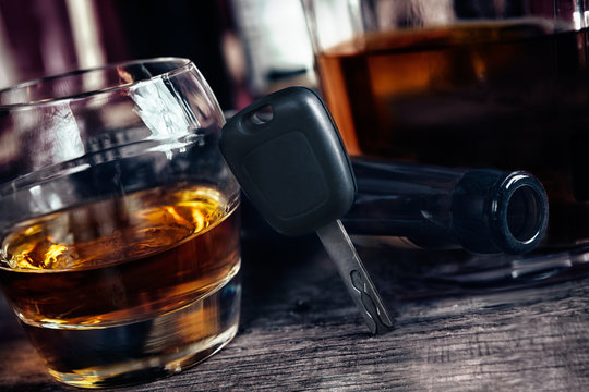 Car keys on glass with alcohol drink, drive under alcohol influence concept