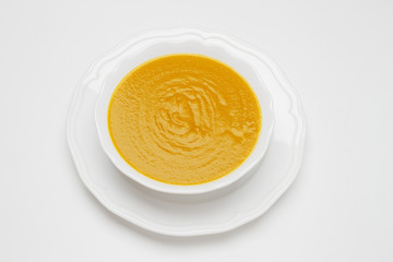 Plate of pea cream soup on white background