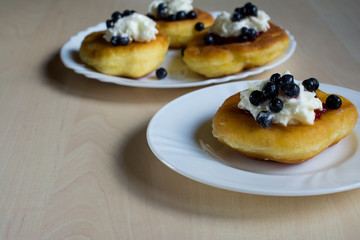 Sweet homemade donuts with jam and whipped cream and blueberries