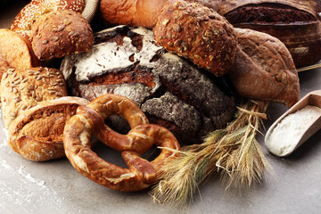 Different kinds of bread and bread rolls on board from above. Kitchen or bakery poster design.