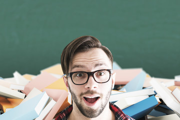 Surprised man in glasses and books in class
