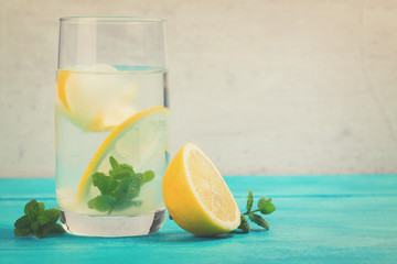 Lemonade homemade drink - one glass with ice and mint, retro toned