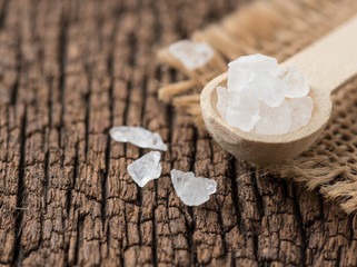 Rock sugar with spoon on wood background.