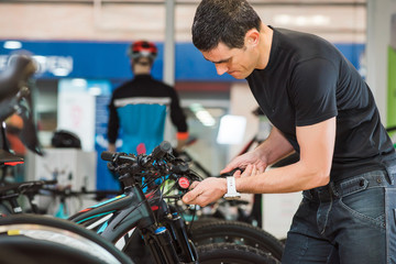 Male master is fixing the bicycle in a special workshop