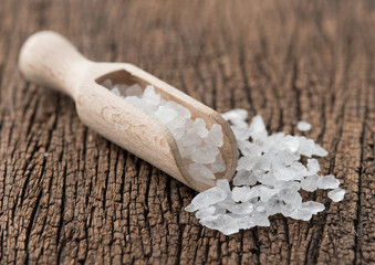 Rock sugar with wooden scoop on wood background.