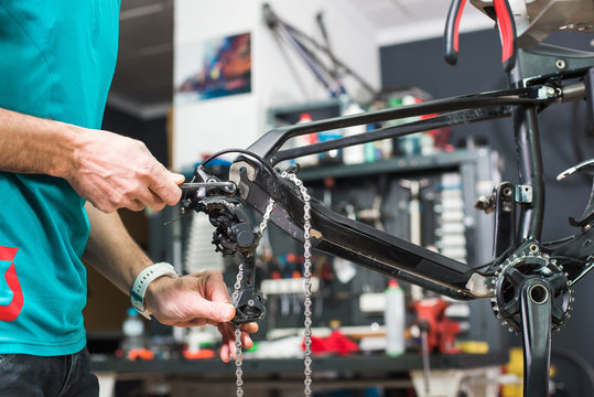Closeup of male hands fixing chain mechanism of the bicycle